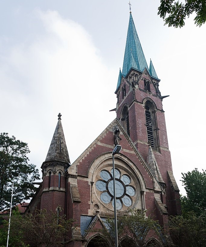 Bild der evangelischen Pauluskirche von der Straße. Sichtbar sind das große Rosettenfenster über dem Eingang und der Turm.